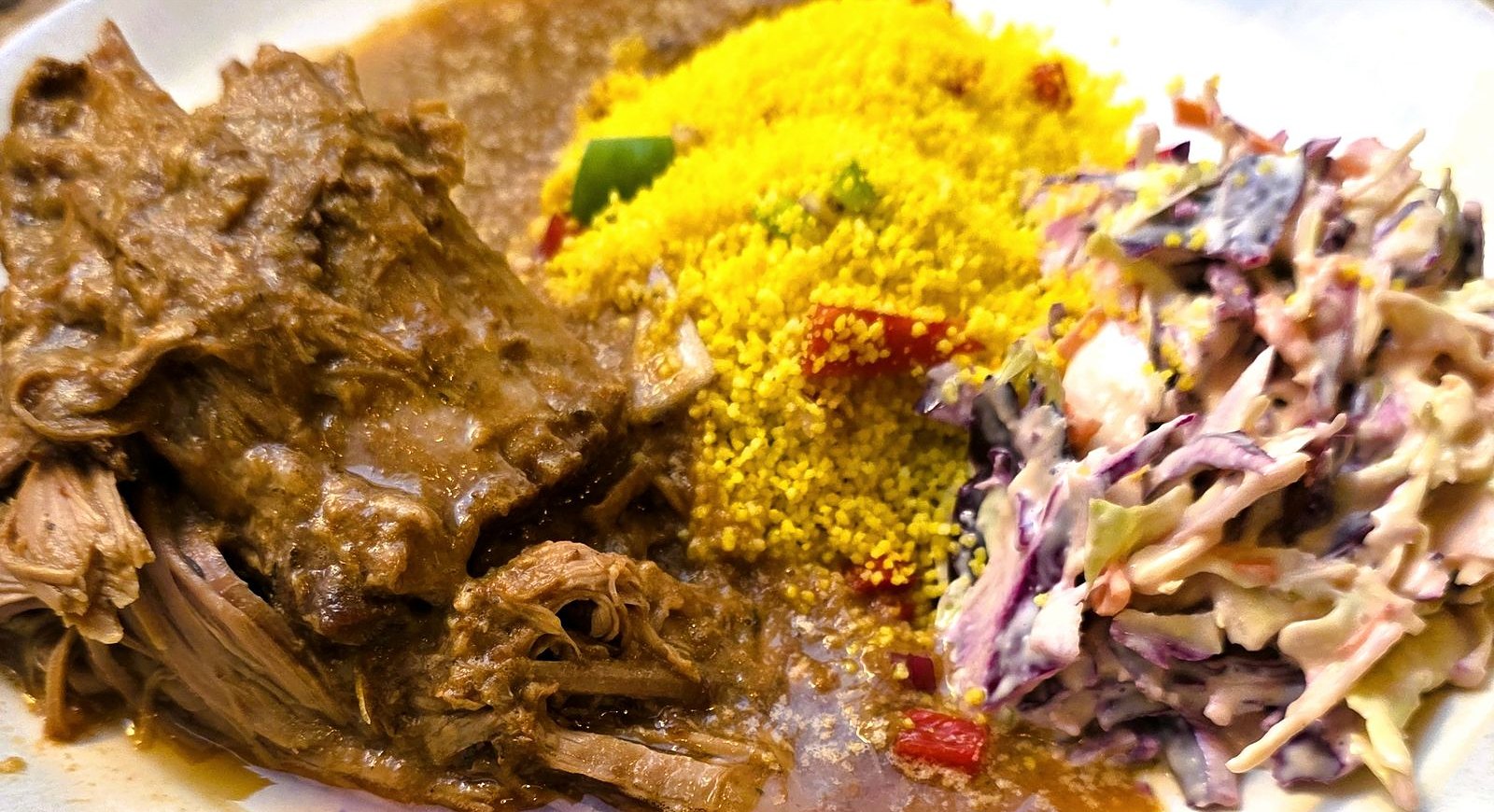Porcolento no prato: cachaço de porco desfiado com molho, couscous e coleslaw