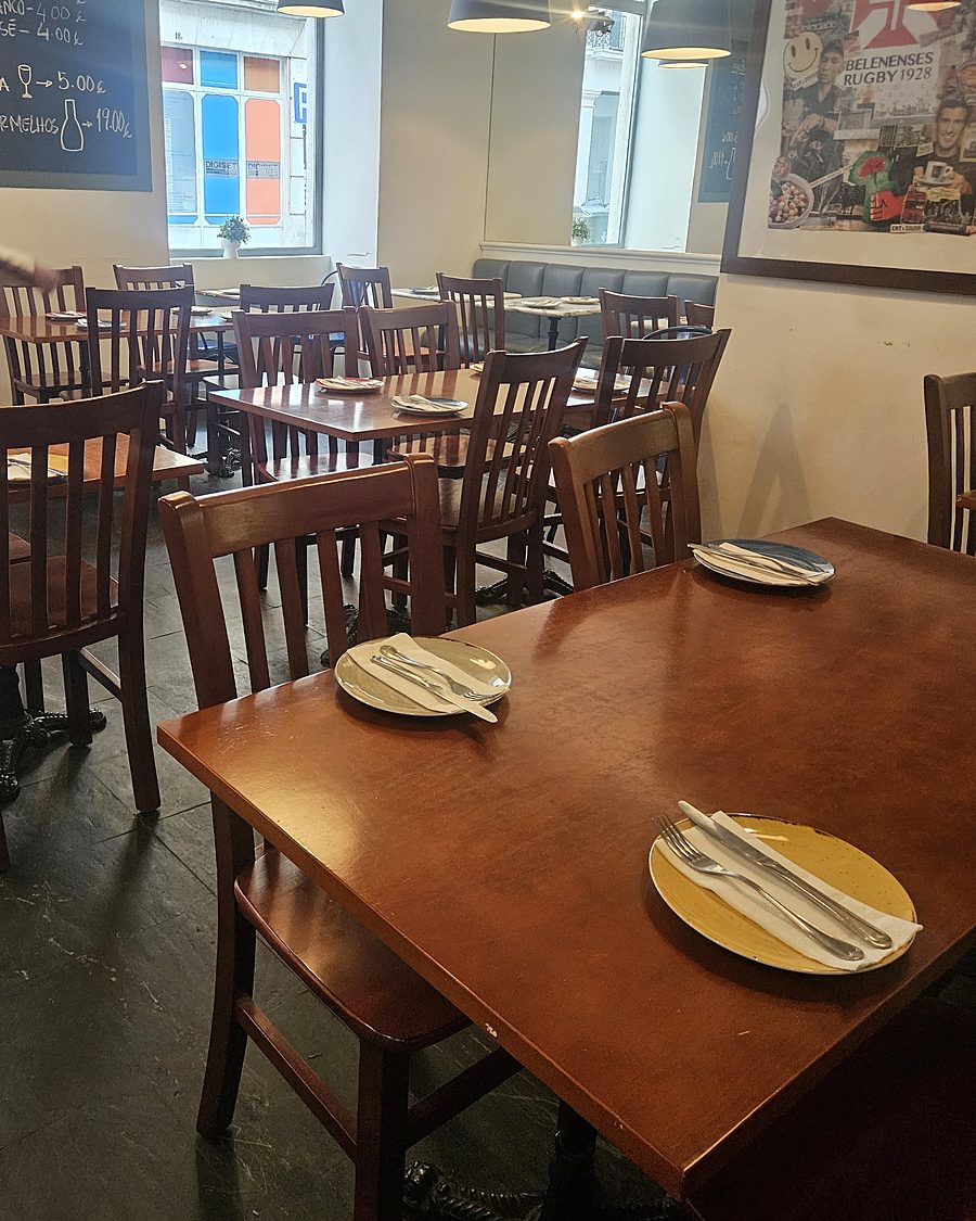 A sala do Sucolento, com mesas de madeira e janelas para a rua